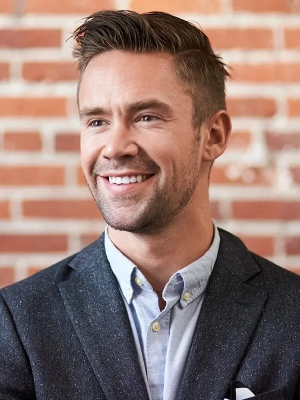 imgi_5_young-businessman-standing-against-brick-wall-in-m-D2ZSHCQ-rbdywd7qnvp3x8yjla7x0kqe7fo7v74rzl6es2i0jk